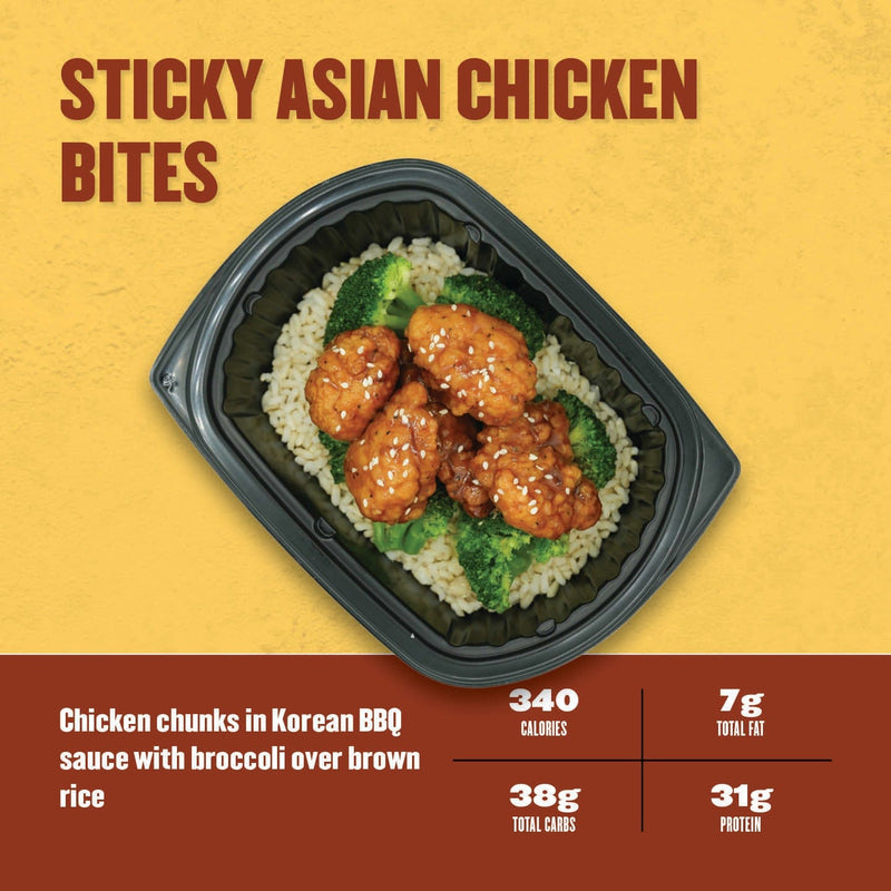 Sticky Asian Chicken Bites – glazed chicken chunks in Korean BBQ sauce with steamed broccoli over brown rice in a black meal tray.
