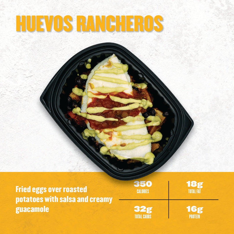 Huevos Rancheros – fried eggs served over roasted potatoes, black beans, and salsa, topped with creamy guacamole drizzle in a black container from Clean Eatz Kitchen.