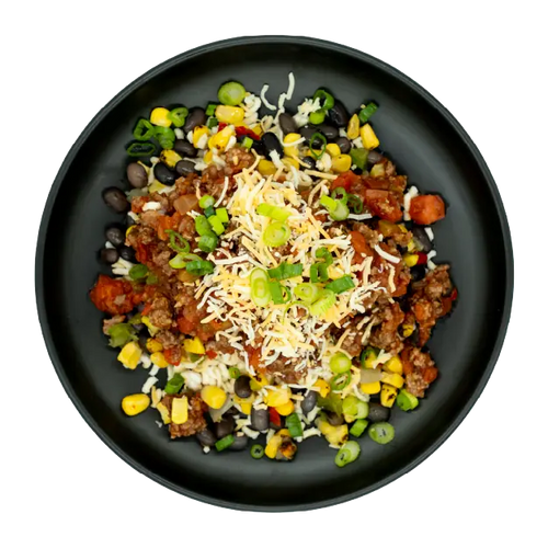 Chicken taco bowl with corn, black beans, salsa, shredded cheese, and green onions over rice on a black plate.