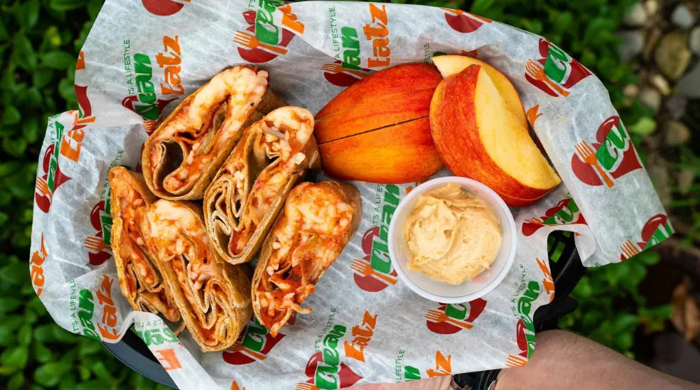 Balanced meal with grilled chicken wraps, fresh apple slices, and sauce on wrapper