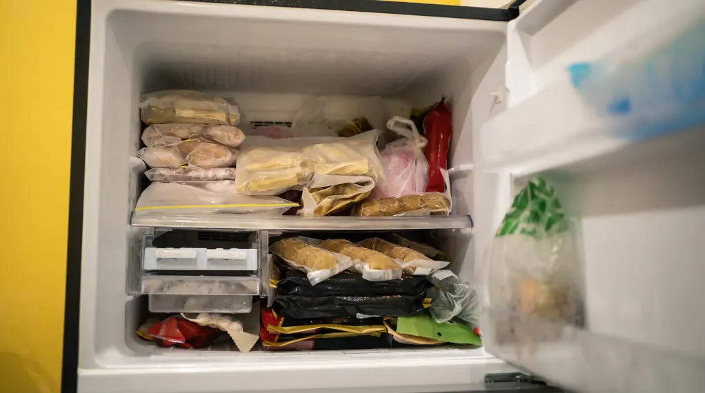 Freezer meal compartment stocked with packaged prepared meals and frozen portions