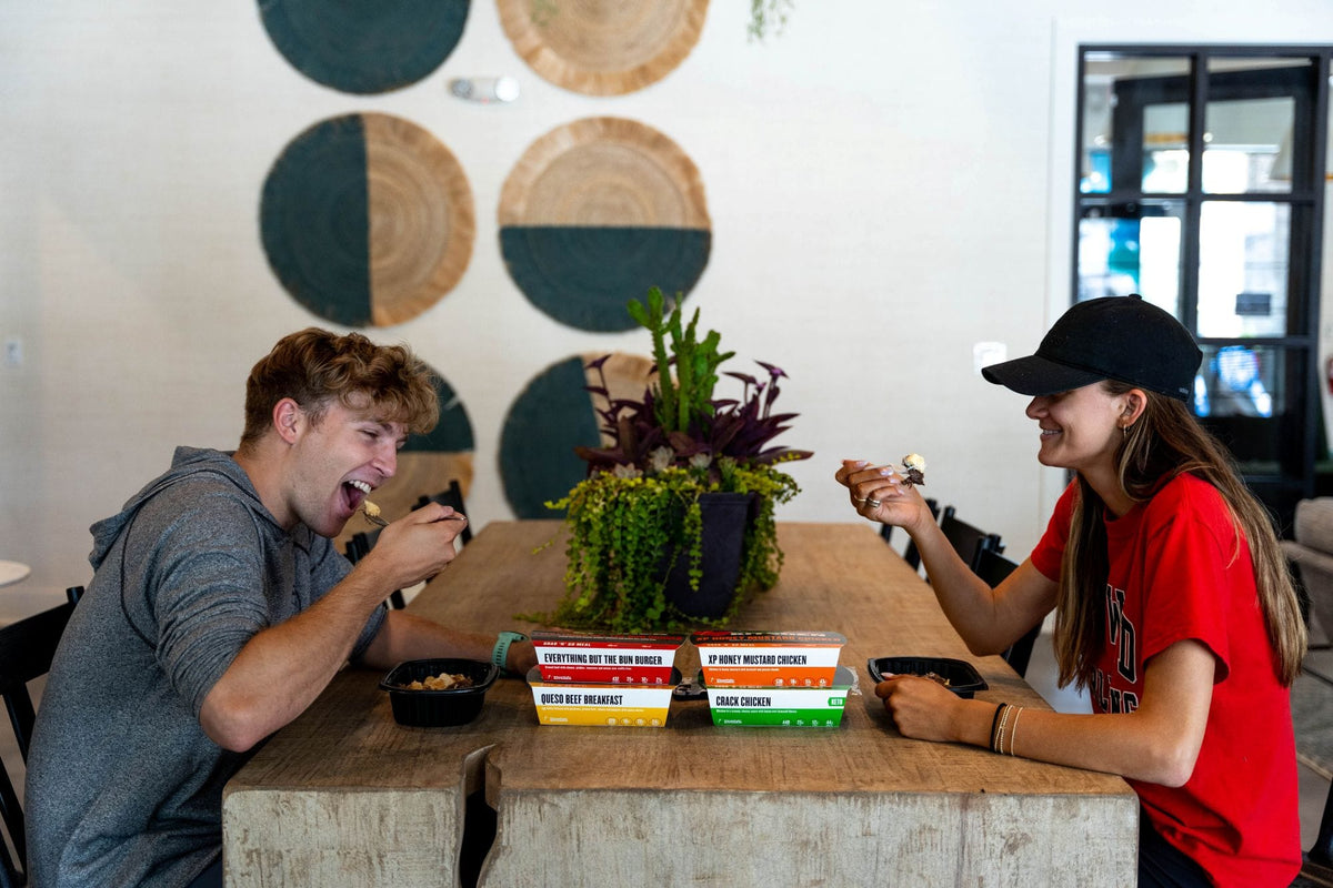 Couple eating Clean Eatz Kitchen meals at a dinner table