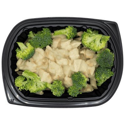 Chicken in a creamy Dijon alfredo sauce over penne pasta with broccoli florets in a black meal tray.