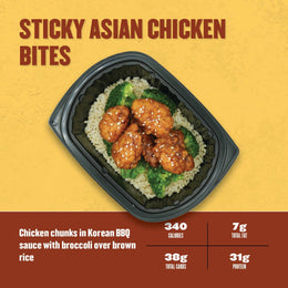 Sticky Asian Chicken Bites – glazed chicken chunks in Korean BBQ sauce with steamed broccoli over brown rice in a black meal tray.
