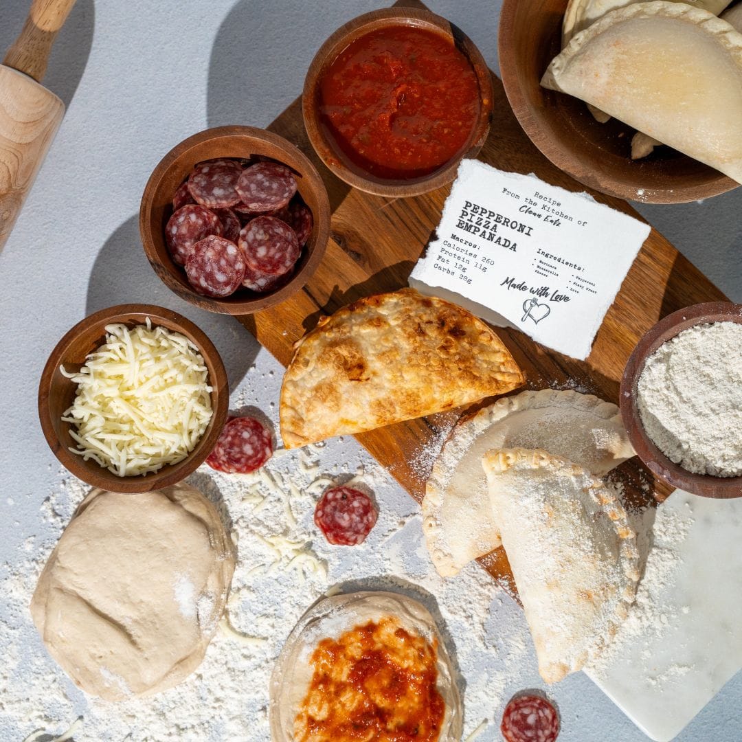 Assorted ingredients for making empanadas on a wooden board with a white background