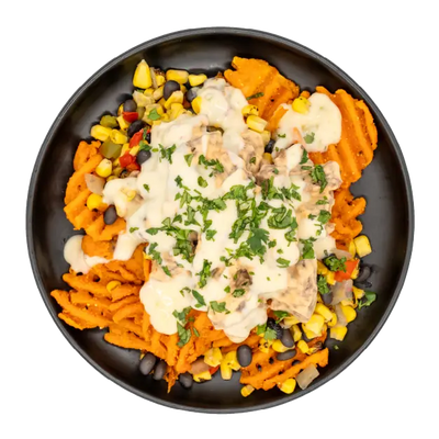 Adobo steak nachos with sweet potato waffle fries, corn, black beans, queso, and herbs on a black plate.