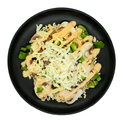 Shredded beef with peppers, onions, mozzarella, and creamy sauce over brown rice on a black plate.