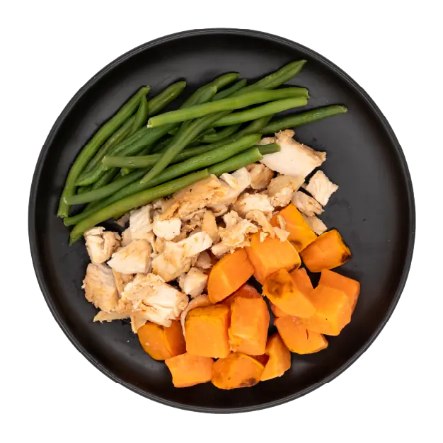 Chicken breast with green beans and roasted sweet potatoes on a black plate.