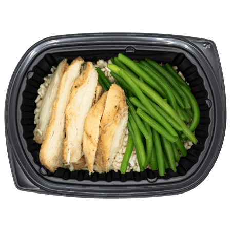 Sliced chicken strips with green beans over rice in a black meal tray.