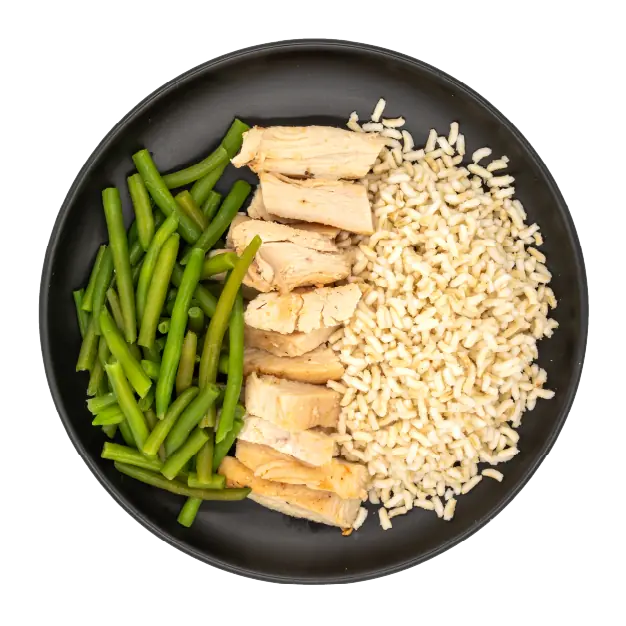 Chicken strips with green beans and brown rice on a black plate.