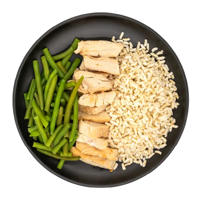 Chicken strips with green beans and brown rice on a black plate.