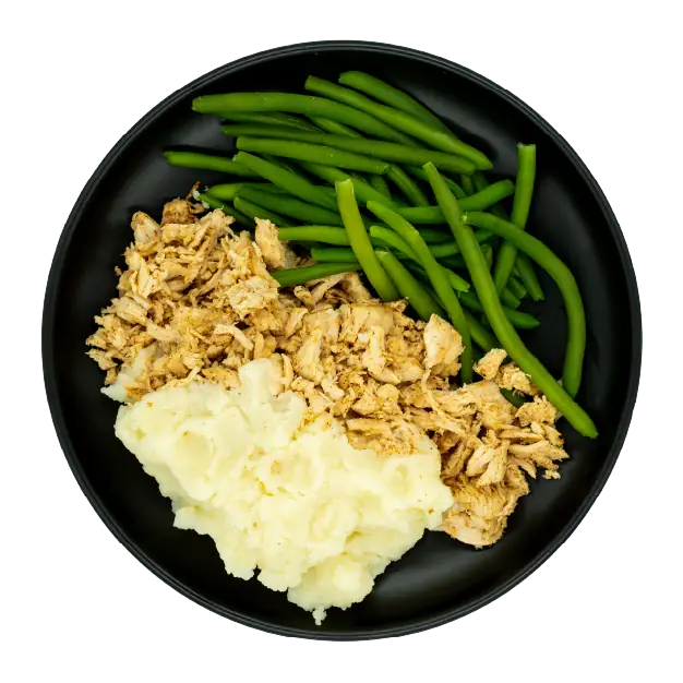 Pulled chicken with green beans and mashed potatoes on a black plate.