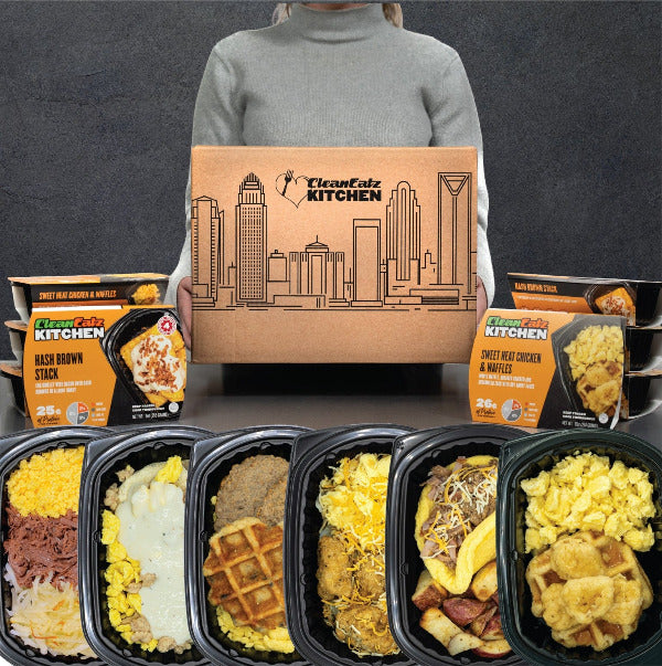 Person holding a 'Clean Eatz Kitchen' box with breakfast meal plan meals