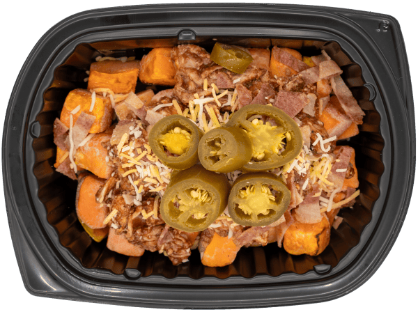Chopped brisket over roasted sweet potatoes with shredded cheese, bacon, and sliced jalapeños in a black meal tray.