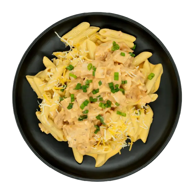 Buffalo chicken mac and cheese topped with shredded cheese and green onions on a black plate.