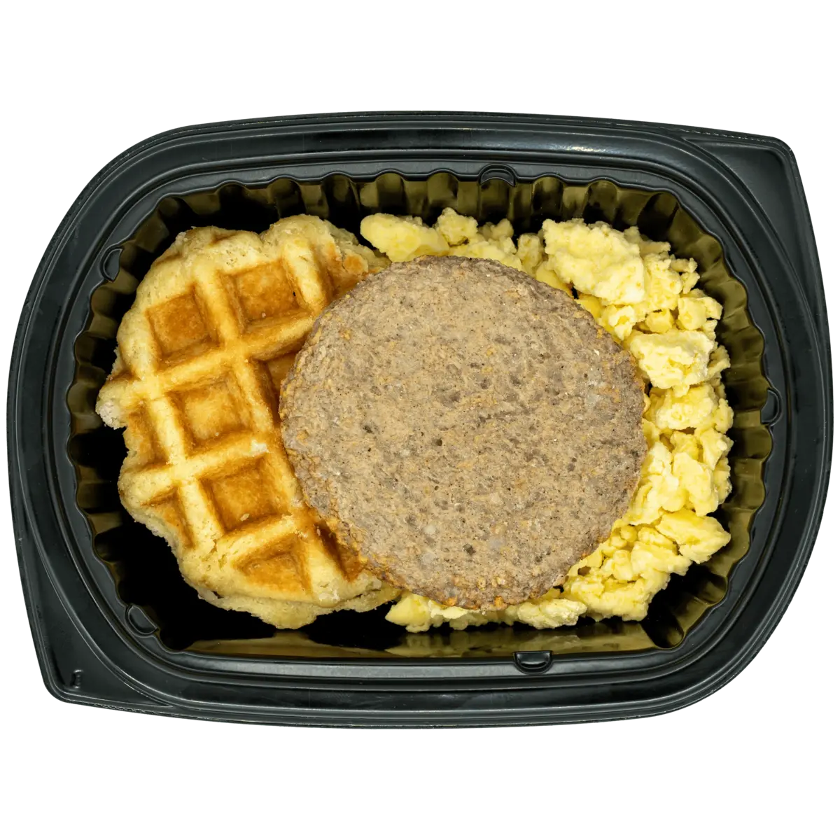 A breakfast meal in a black plastic clamshell container, featuring a golden-brown waffle, a round brown sausage patty, and scrambled yellow eggs on a white background.