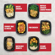 Assorted Clean Eatz Kitchen meals from Clean Box B including Aussie Chicken, Buffalo Chicken Loaded Wedges, Cowboy Mac & Cheese, Pub Chicken, Queso Beef Burrito, and Sesame Chicken in black trays on a light background.
