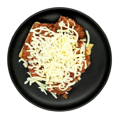 Chicken sausage lasagna with marinara sauce and shredded mozzarella cheese on a black plate.
