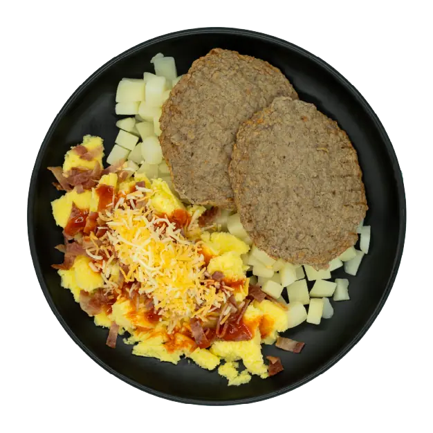 Turkey sausage patties with roasted red potatoes, scrambled eggs, gravy, shredded cheese, and bacon in a black meal tray.