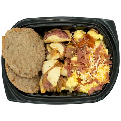 Turkey sausage patties with roasted red potatoes, scrambled eggs, gravy, shredded cheese, and bacon in a black meal tray.