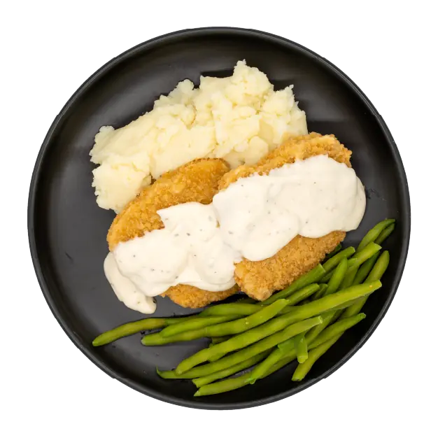 Country steak with mashed potatoes, green beans, and white gravy on a black plate.