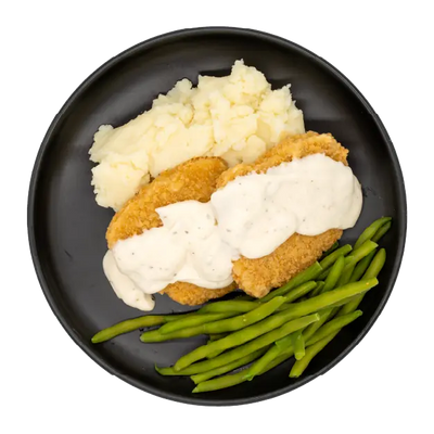 Country steak with mashed potatoes, green beans, and white gravy on a black plate.