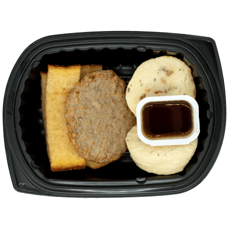 French toast stick, turkey sausage patty, two egg bites, and a side cup of syrup in a black meal tray.
