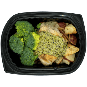 Chicken breast topped with a creamy garden herb sauce with broccoli and roasted red potatoes in a black meal tray.