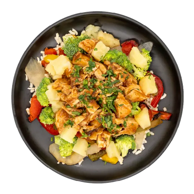 Jamaican jerk chicken with rice, broccoli, pineapple, and peppers on a black plate.