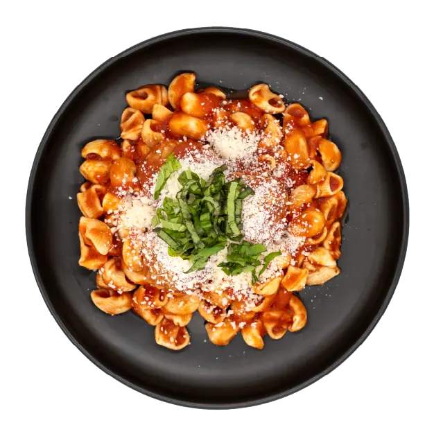 Meatballs in marinara sauce over pasta topped with grated parmesan and basil on a black plate.