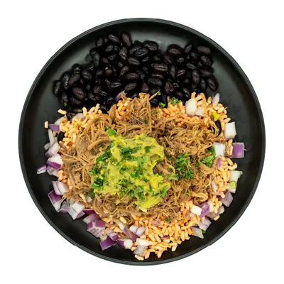 Mojo pork bowl with black beans, rice, red onions, and guacamole on a black plate.