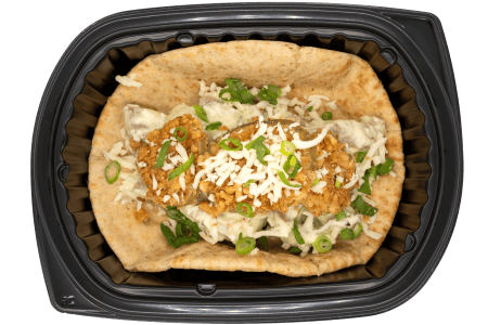 Pita popper stuffed with crispy chicken, shredded cheese, and green onions, served with a creamy sauce in a black meal tray.