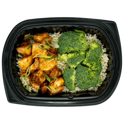 Prepared meal with tofu and vegetables in a black container on a white background