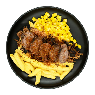 BBQ pulled pork with sliced sausage, corn, and mac and cheese on a black plate.