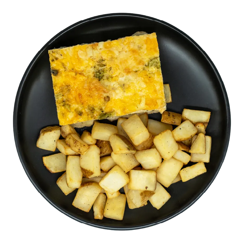 Cheesy egg quiche with broccoli and vegetables, served with roasted potatoes on a black plate.