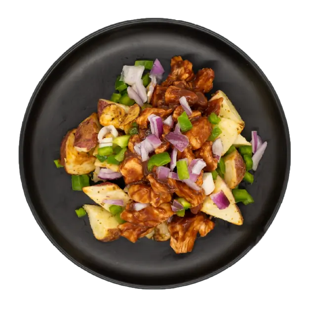 BBQ chicken with peppers and onions over roasted red potatoes on a black plate.
