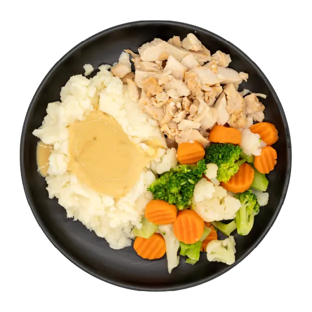 Roasted turkey with gravy, mashed potatoes, and mixed vegetables on a black plate.