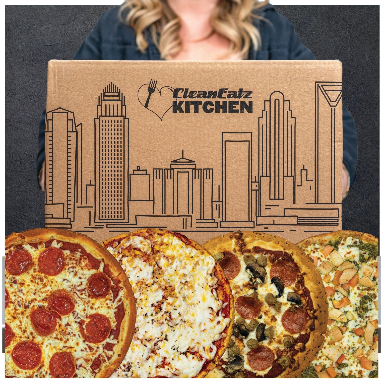 Four pizzas in front of a 'Clean Eatz Kitchen' box with a cityscape design.