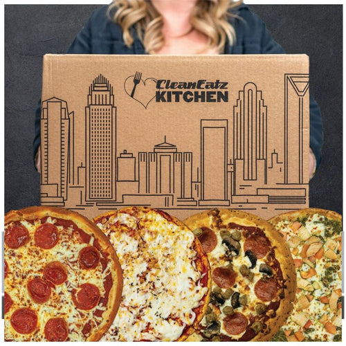 Four pizzas in front of a 'Clean Eatz Kitchen' box with a cityscape design.