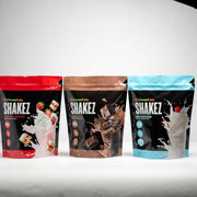 Three packages of Clean Eatz SHAKEZ with different flavors on a white background