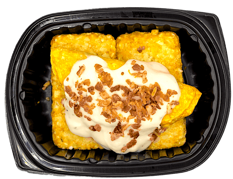 Yellow dessert with whipped cream and caramel bits in a black container