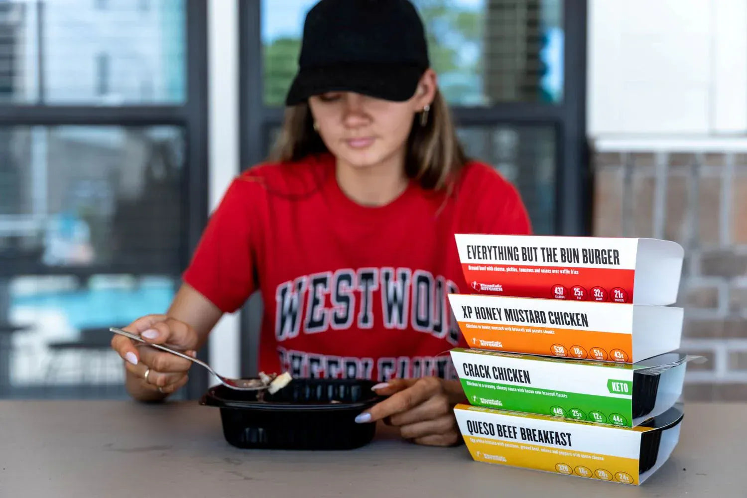 Woman eating Clean Eatz Kitchen delivery meals